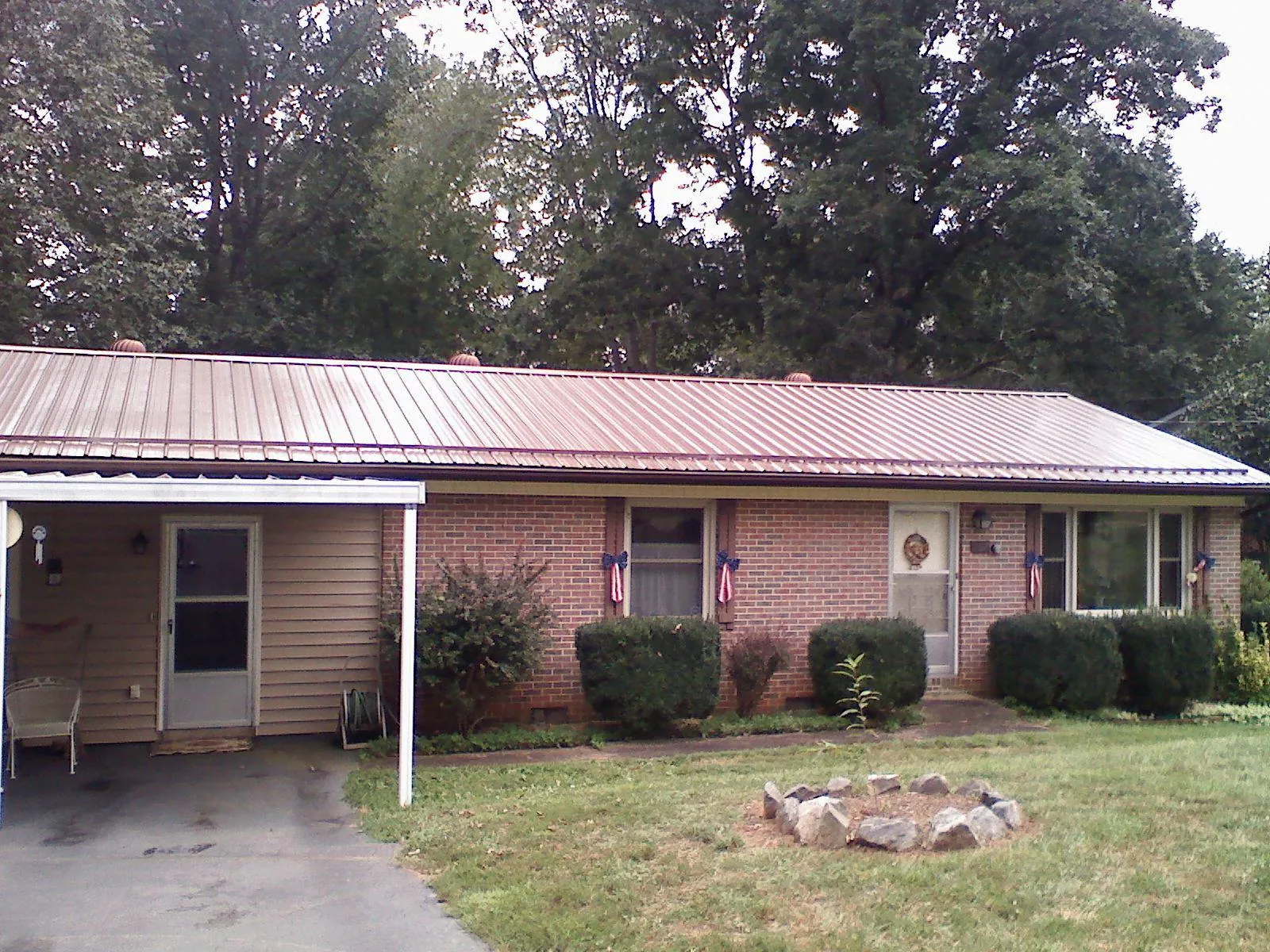 Bronze metal roof and carport on a brick ranch home — Roof Repair work by our crew in Maysville