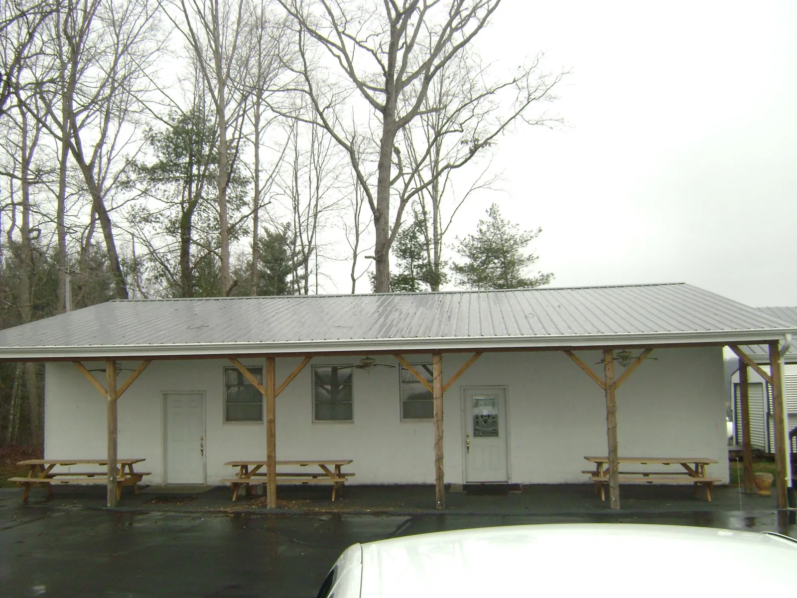 Gray metal roof over a block building with a timber post porch in Maysville